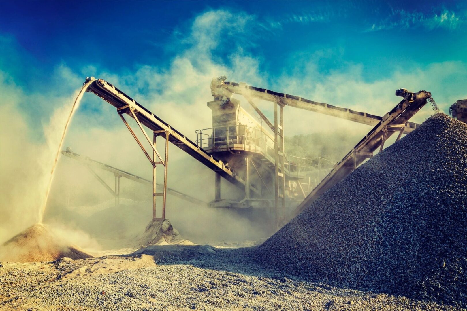 A large pile of gravel next to a conveyor belt.
