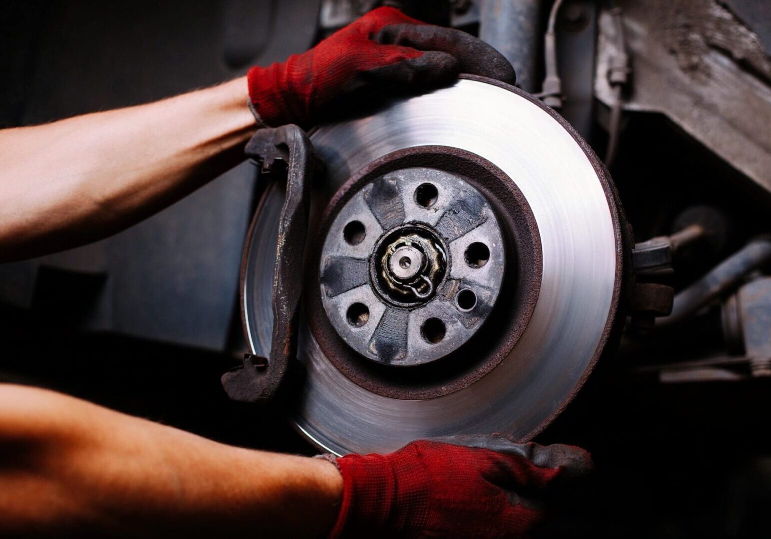 A person holding onto the brake disc of their car